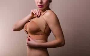 Young woman wearing a compressing bra after a breast enhancement surgery