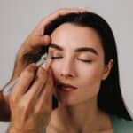 Doctor marking patient’s upper eyelids with medical pen for blepharoplasty, concept of precise planning for eyelid lift surgery