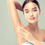 Woman showing smooth upper arm and underarm after arm lift.