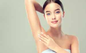 Woman showing smooth upper arm and underarm after arm lift.